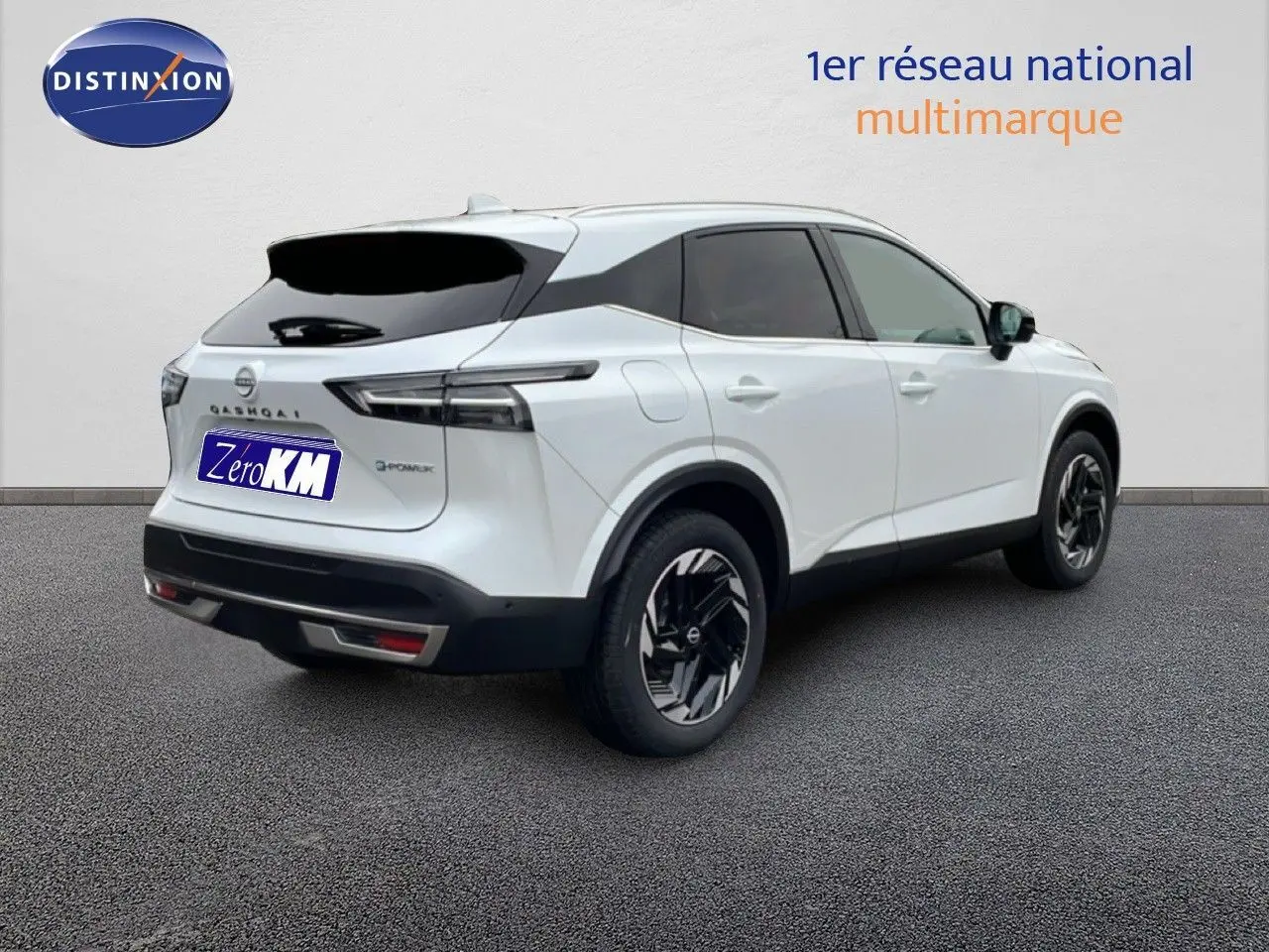 Vue 3/4 arrière droite du Nissan Qashqai blanc nacré métal 2025 avec jantes noires et toit contrasté.