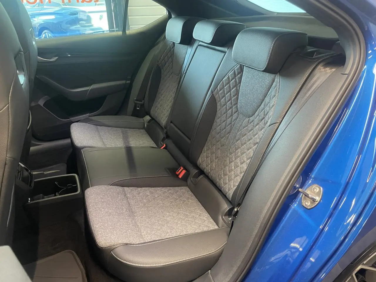 Vue intérieure côté droit sur la banquette arrière bicolore gris et noir d'une Skoda Octavia Bleu foncé 2025 Sportline.