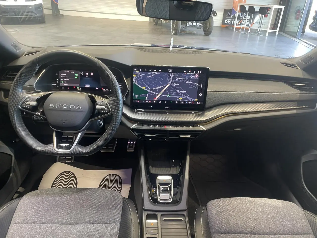 Vue intérieure avant du tableau de bord et volant Skoda Octavia 2025, finition Sportline avec écran tactile central allumé.