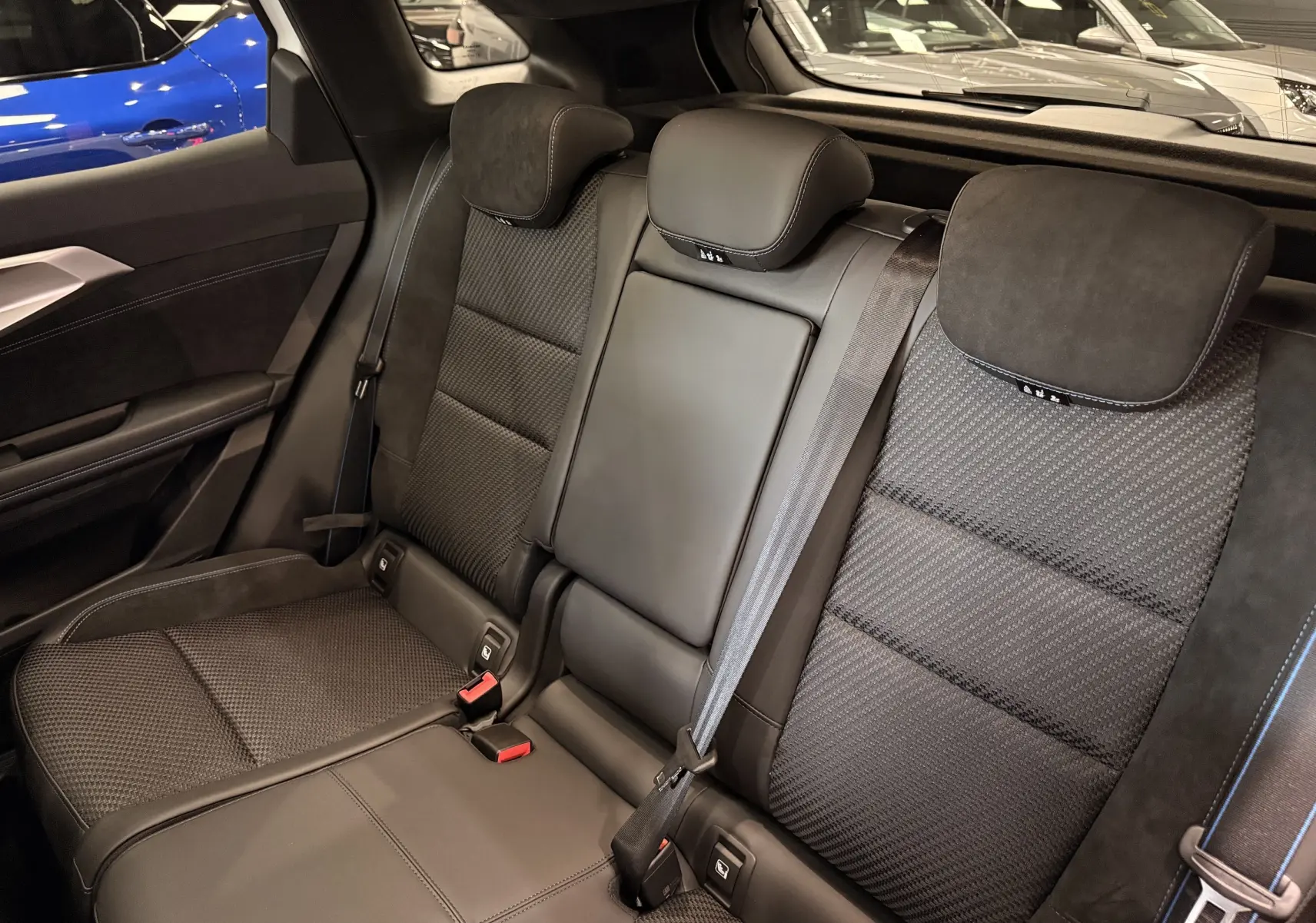 Vue intérieure des sièges arrière noirs en cuir et tissu du Renault Austral Full hybrid 2026, avec ceinture de sécurité visible.