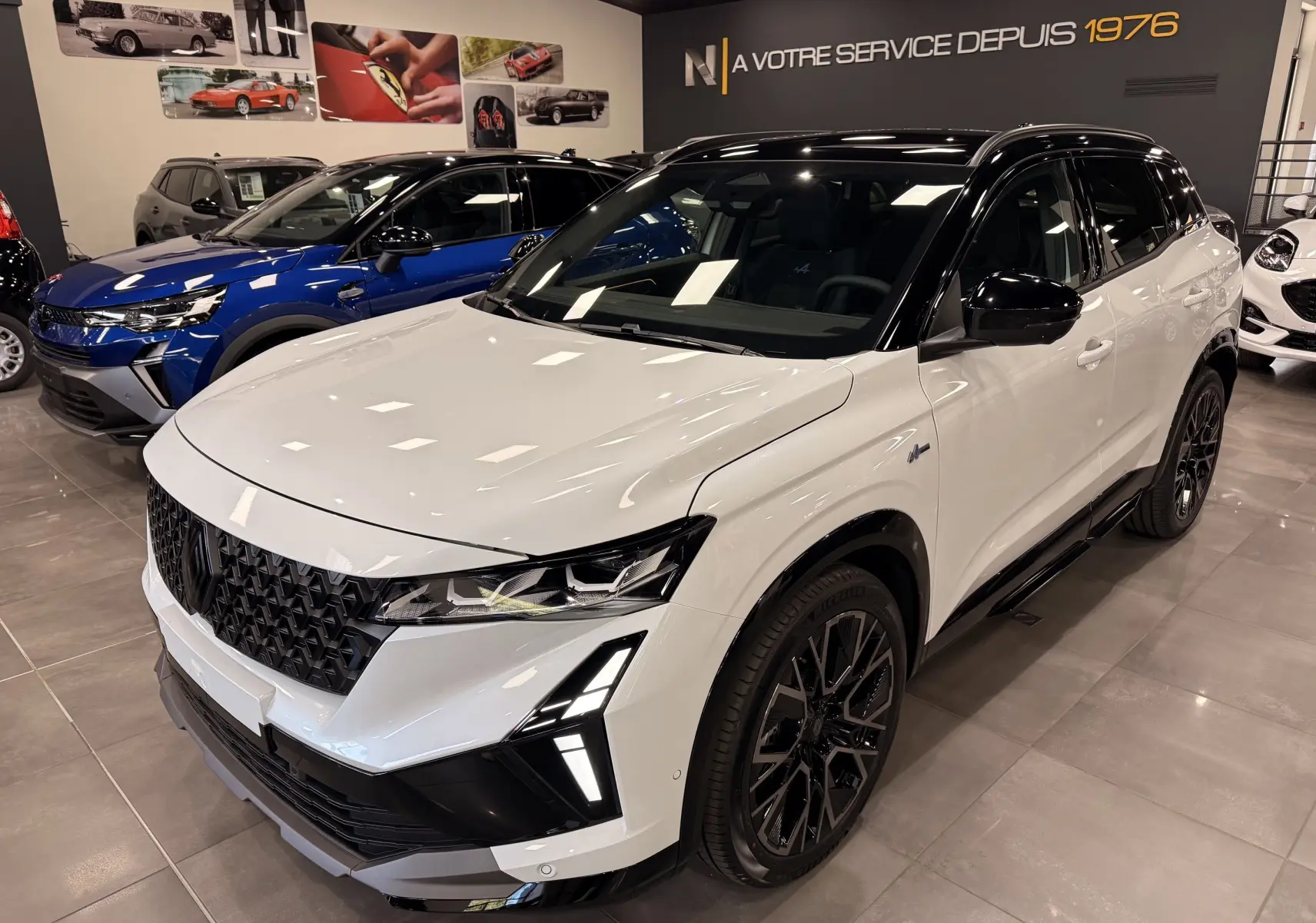 Renault Austral Full hybrid blanc nacré toit noir, vue 3/4 avant droit, avec calandre noire et jantes noires distinctives.