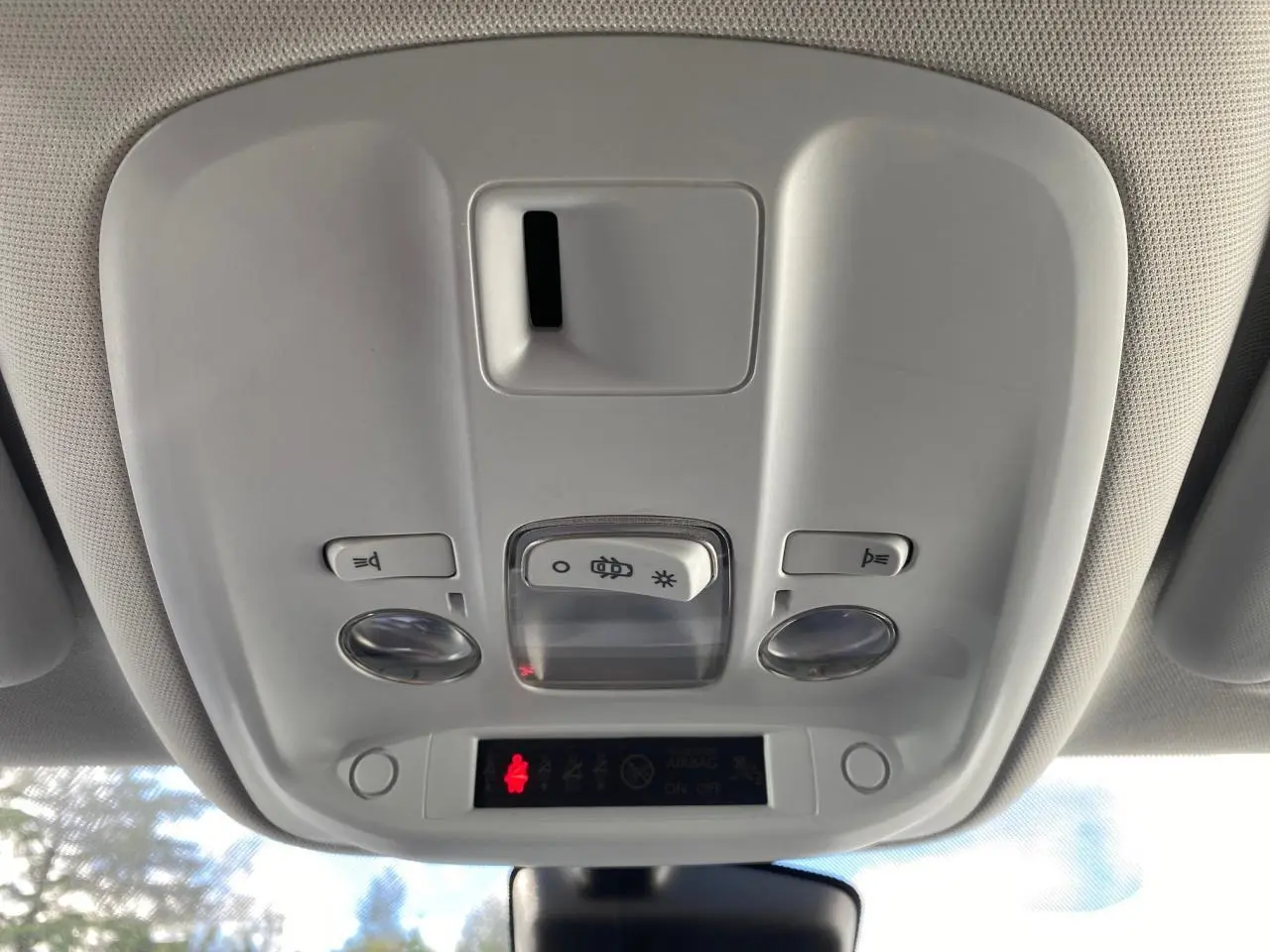 Vue en gros plan du plafonnier intérieur de la Peugeot 308 gris aluminium, montrant les commandes d'éclairage et les voyants.