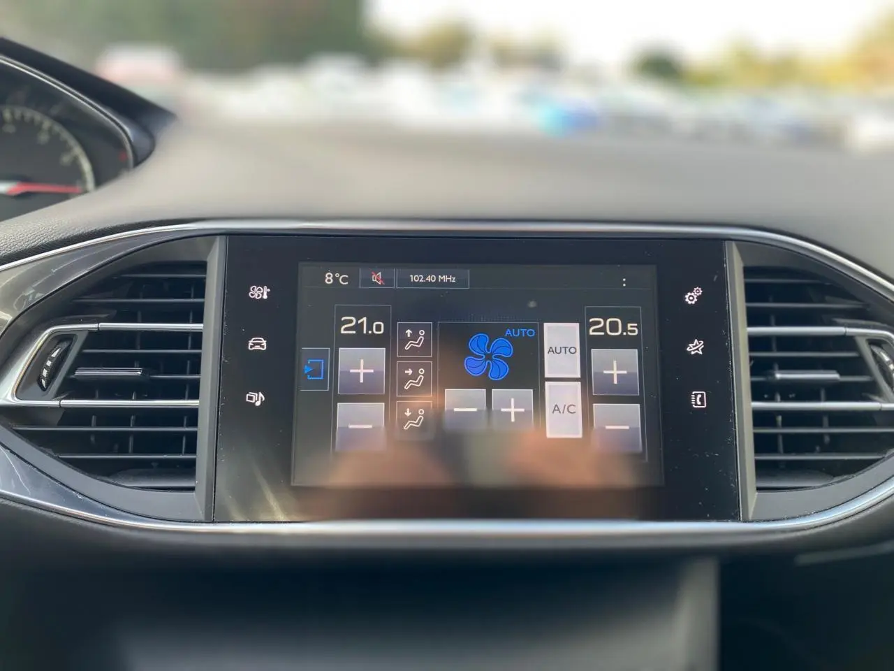 Écran tactile central de la Peugeot 308 gris aluminium 2016 affichant la climatisation automatique bi-zone.