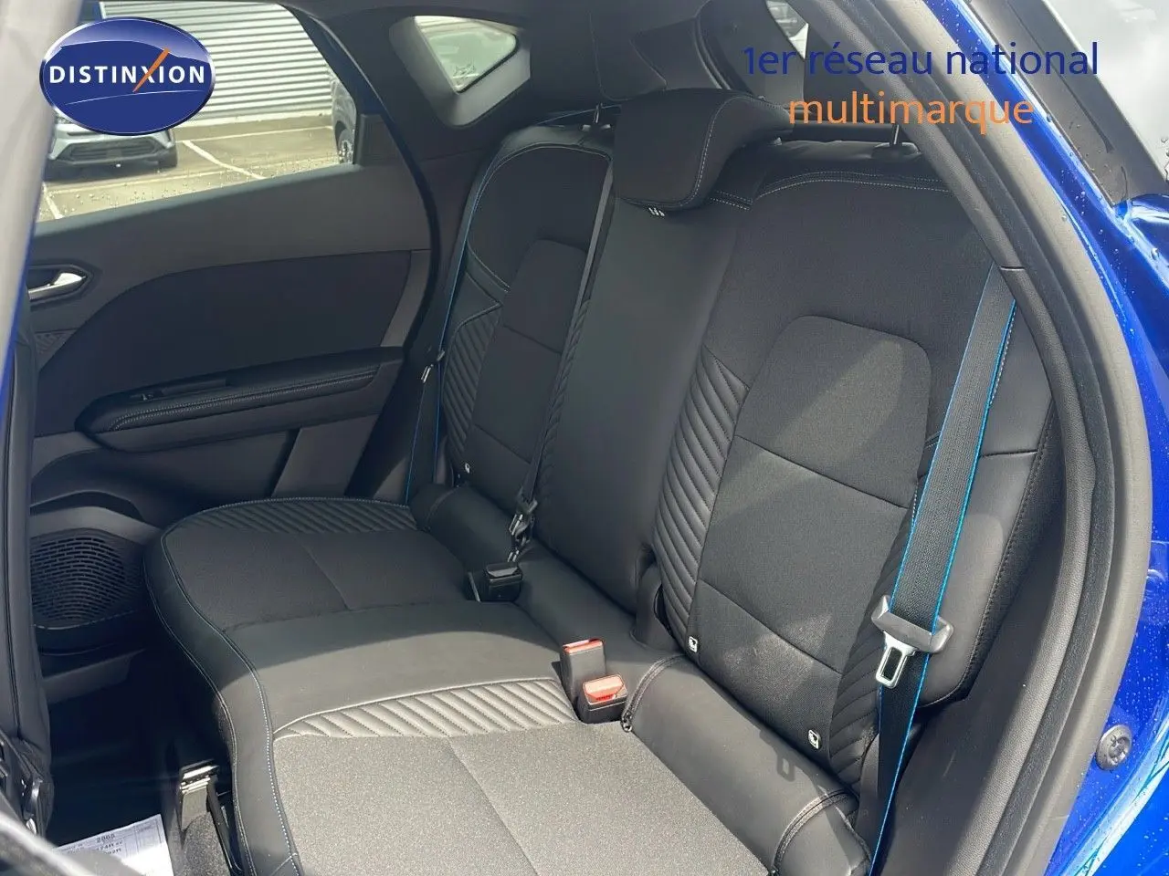 Vue intérieure sur la banquette arrière noire avec surpiqûres bleues du Renault Captur E-Tech hybride 2025 bleu iron metal.