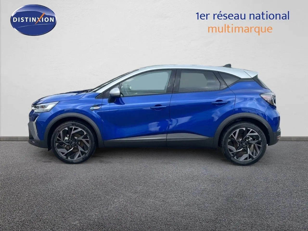 Vue latérale droite d'un Renault Captur E-Tech hybride bleu Iron Metal avec toit gris, jantes noires stylisées.