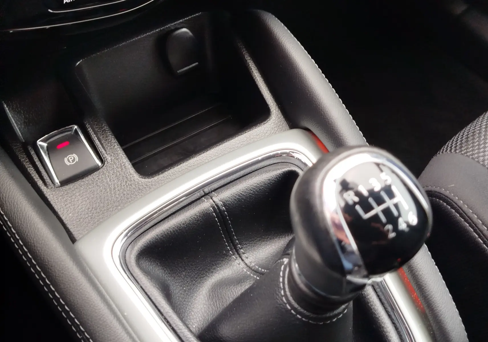 Gros plan sur le volant noir et les commandes intégrées du Nissan Qashqai 2017, tableau de bord partiellement visible.