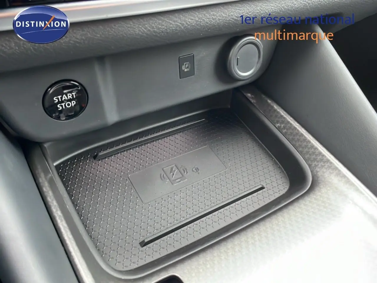 Détail de la console centrale du Nissan Qashqai 2025 avec zone de recharge sans fil et bouton start/stop visible.