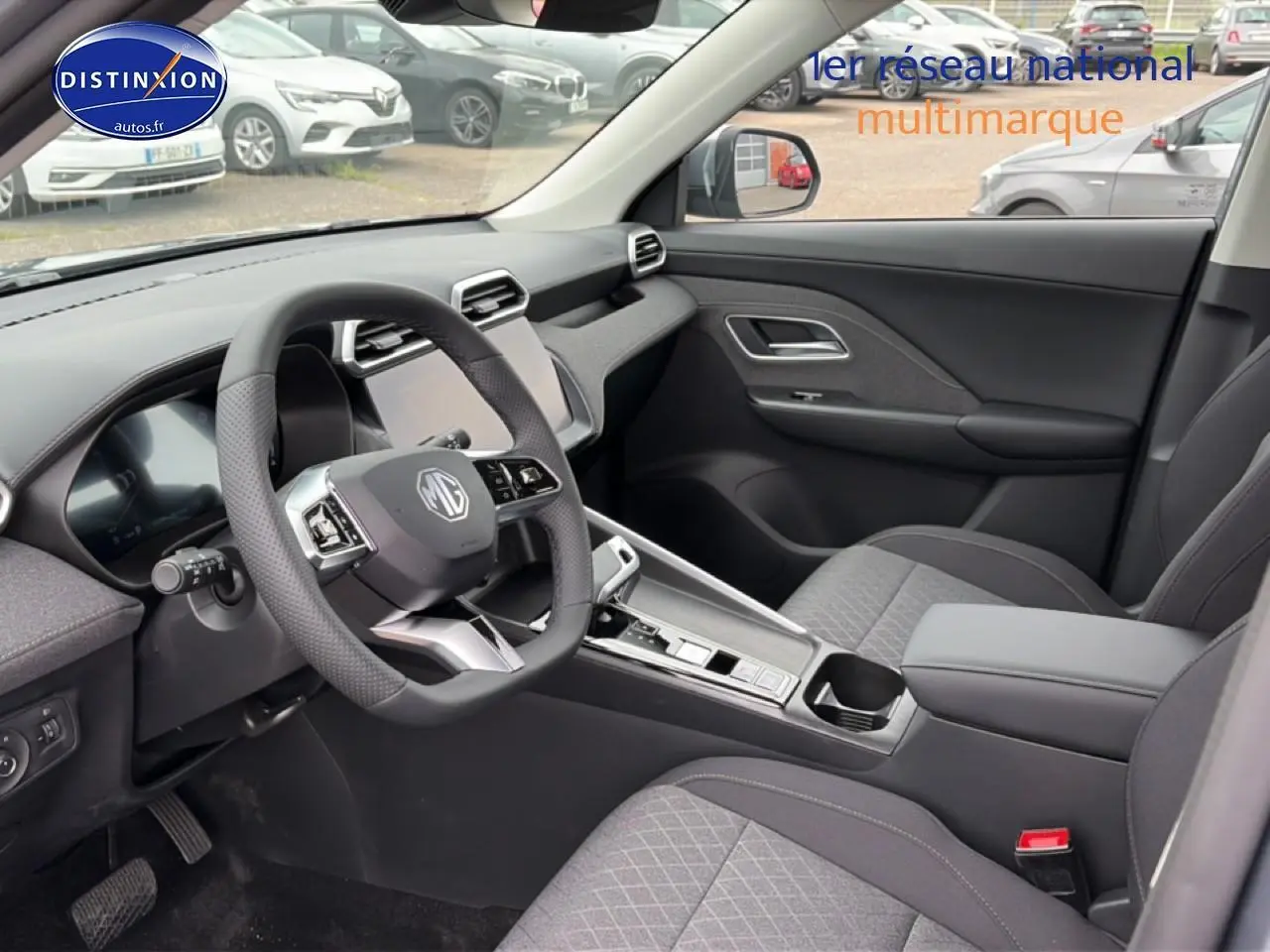 Vue intérieure côté conducteur du MG ZS Hybrid 197 gris, mettant en valeur le volant multifonction et la console centrale moderne.