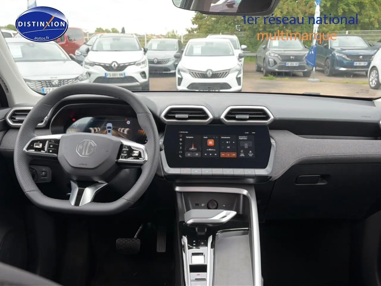 Vue intérieure avant du tableau de bord gris du MG ZS Hybrid 197 avec écran tactile et volant multifonction.