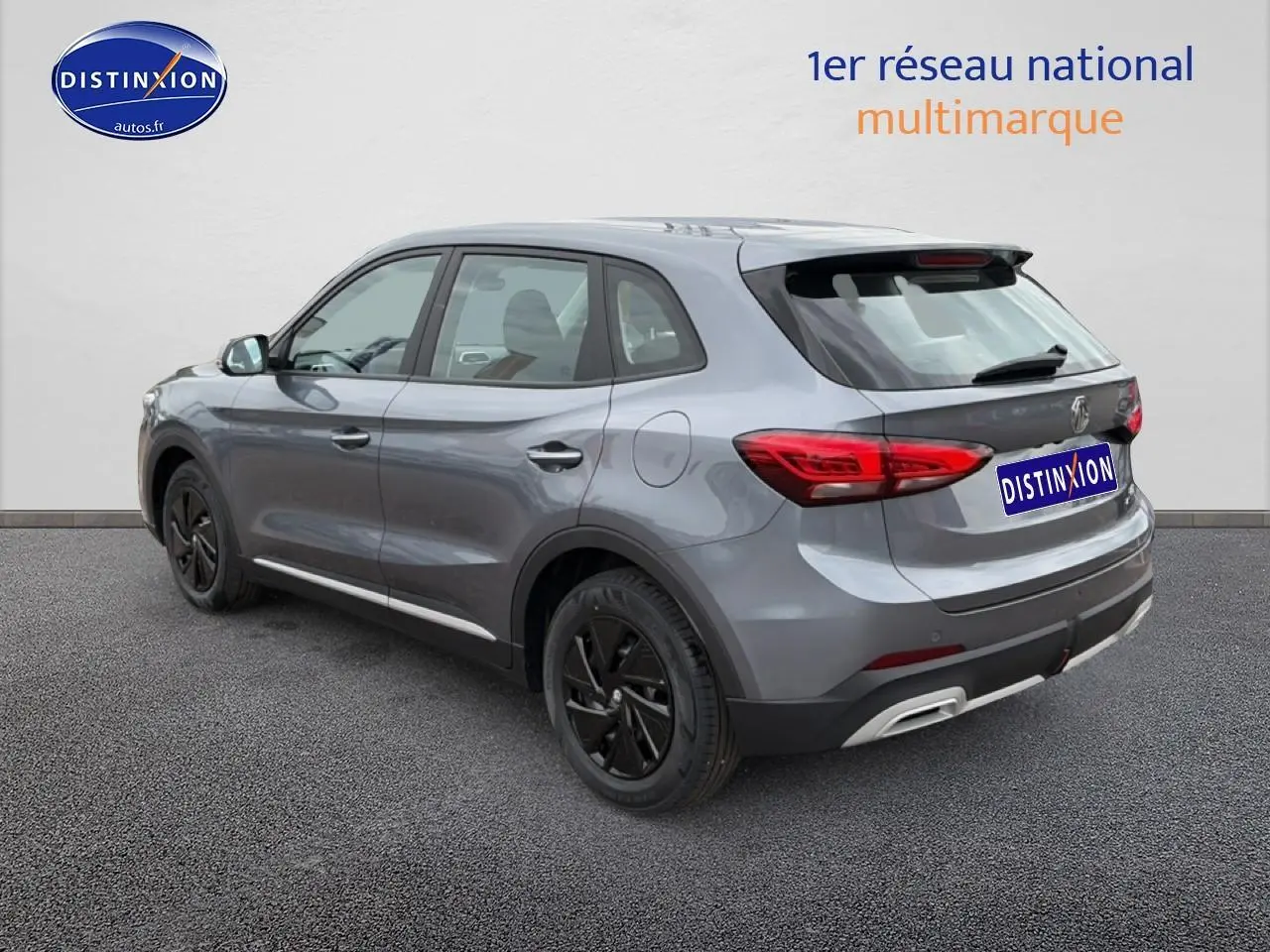 Vue 3/4 arrière droite du SUV MG ZS Hybrid gris avec jantes noires et feux arrière LED visibles.