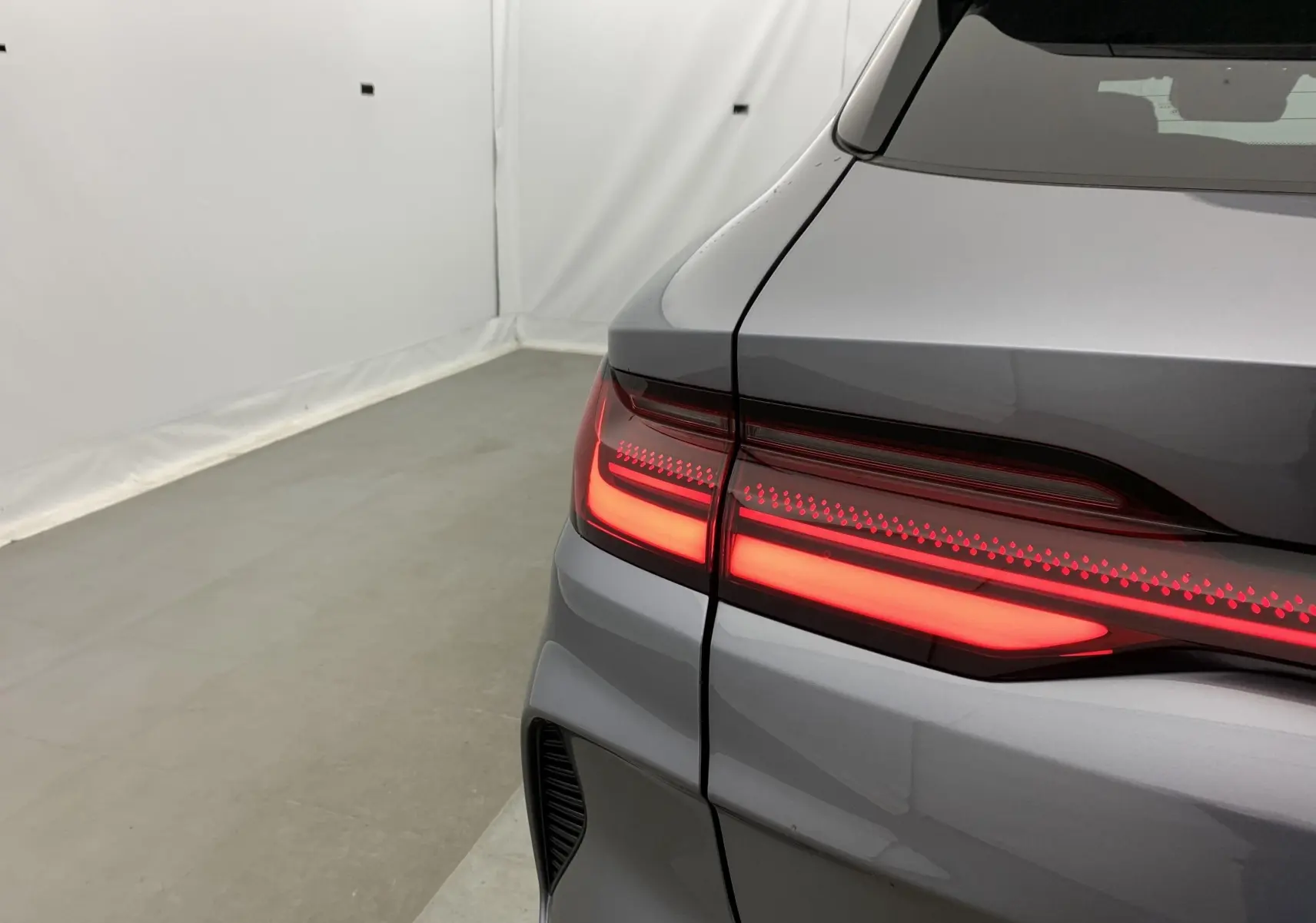 Gros plan sur le feu arrière droit allumé d’un BYD SEAL U TIME GREY METAL, vue arrière en intérieur.