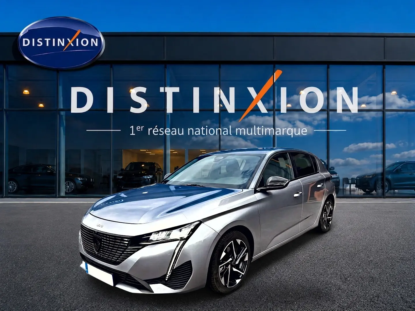 Peugeot 308 gris artense vue 3/4 avant droit, avec calandre noire et jantes alliage distinctives.