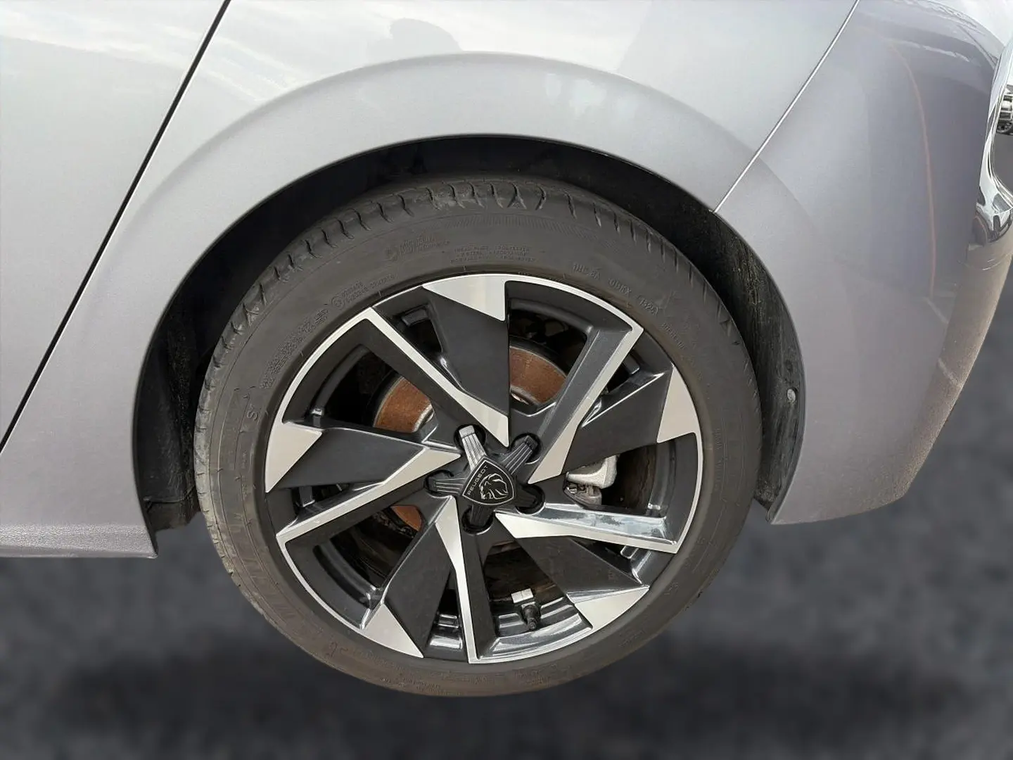 Gros plan sur la roue arrière droite de la Peugeot 308 gris artense avec jante alu noire et argentée au design moderne.