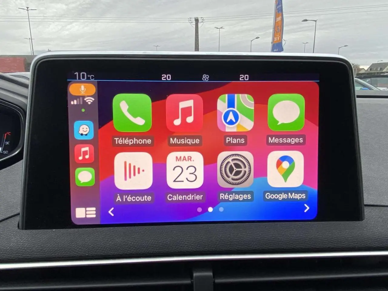 Écran tactile central du Peugeot 3008 2017 montrant l'interface Apple CarPlay avec plusieurs applications colorées.