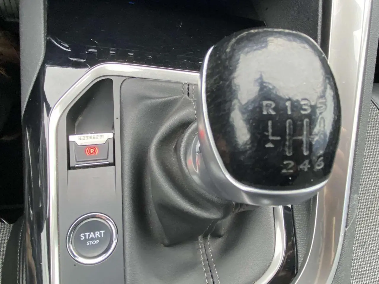 Gros plan sur le levier de vitesse manuel noir du Peugeot 3008 avec bouton Start/Stop et frein à main électronique.