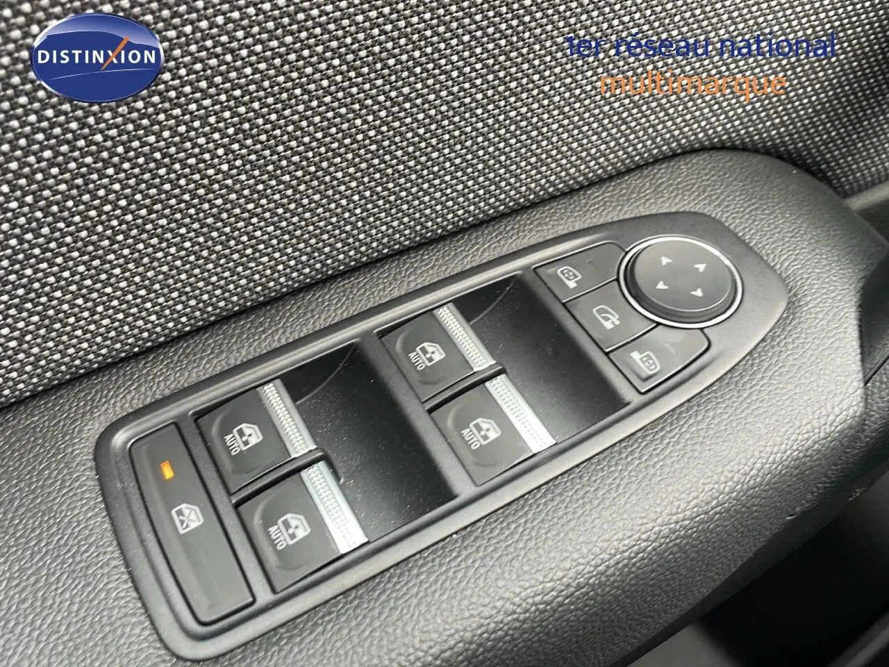 Gros plan sur les commandes de lève-vitres et rétroviseurs côté conducteur du Renault Captur gris Rafale 2025.