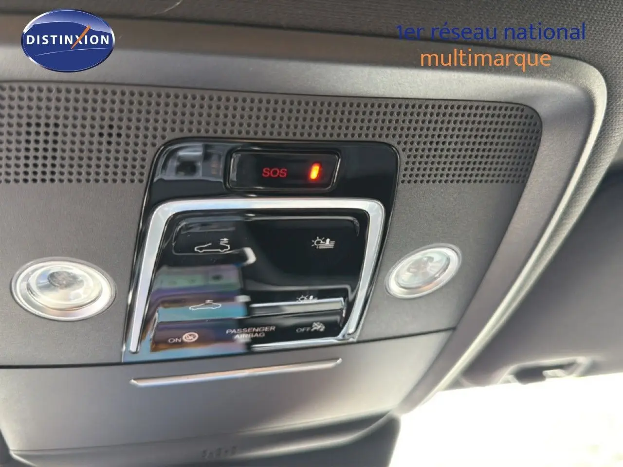 Vue en gros plan du panneau de commandes de toit intérieur du BYD SEAL U blanc métal, avec bouton SOS et éclairage intégré.