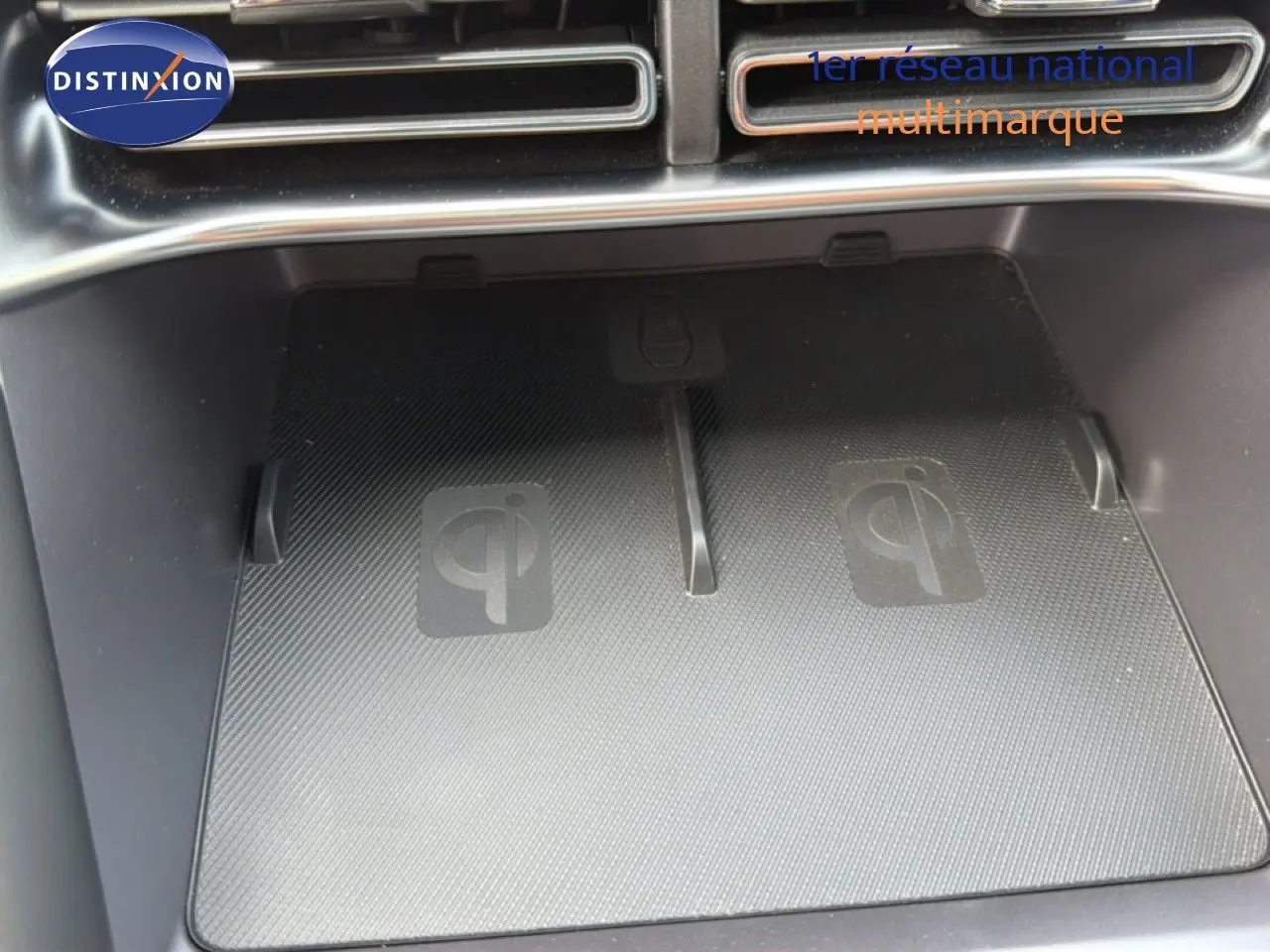 Gros plan sur le chargeur sans fil Qi intégré dans la console centrale du BYD SEAL U blanc métal 2026.