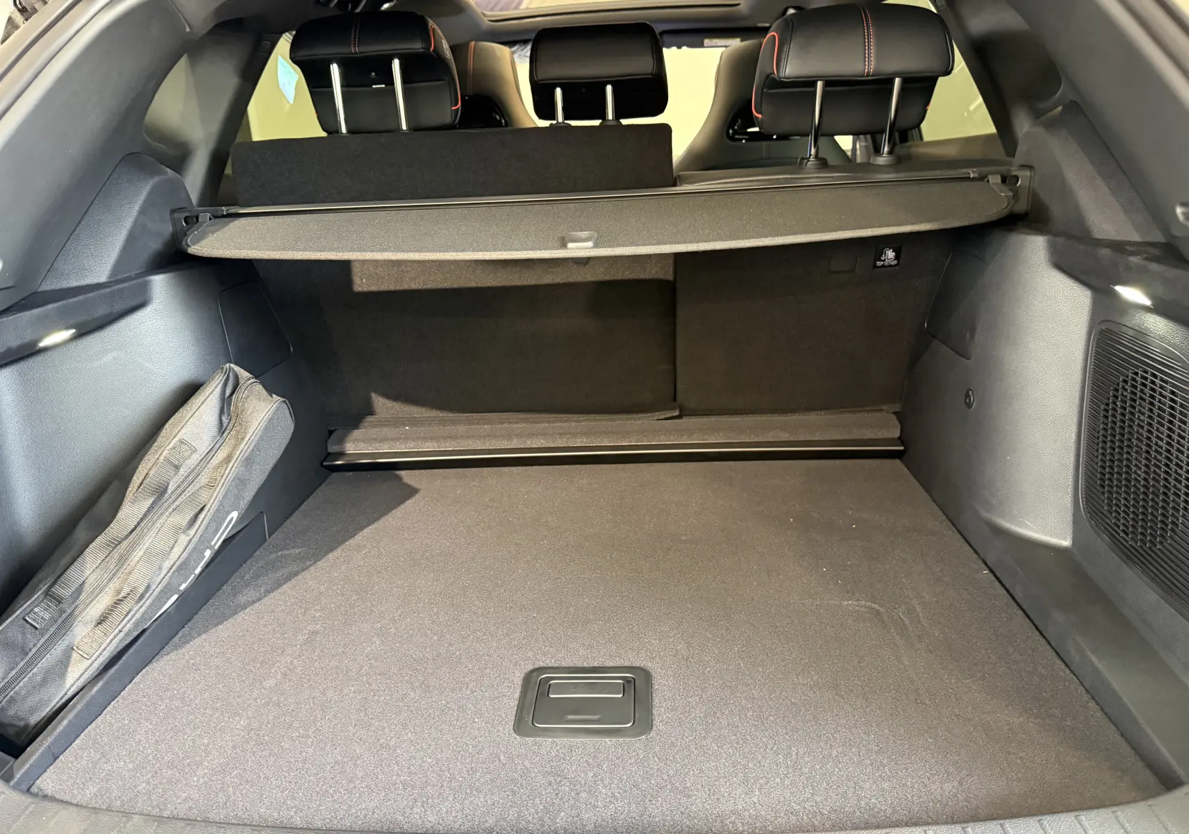 Vue intérieure du coffre spacieux du BYD SEAL U 2026, avec cache-bagages et sièges arrière noirs à surpiqûres rouges.