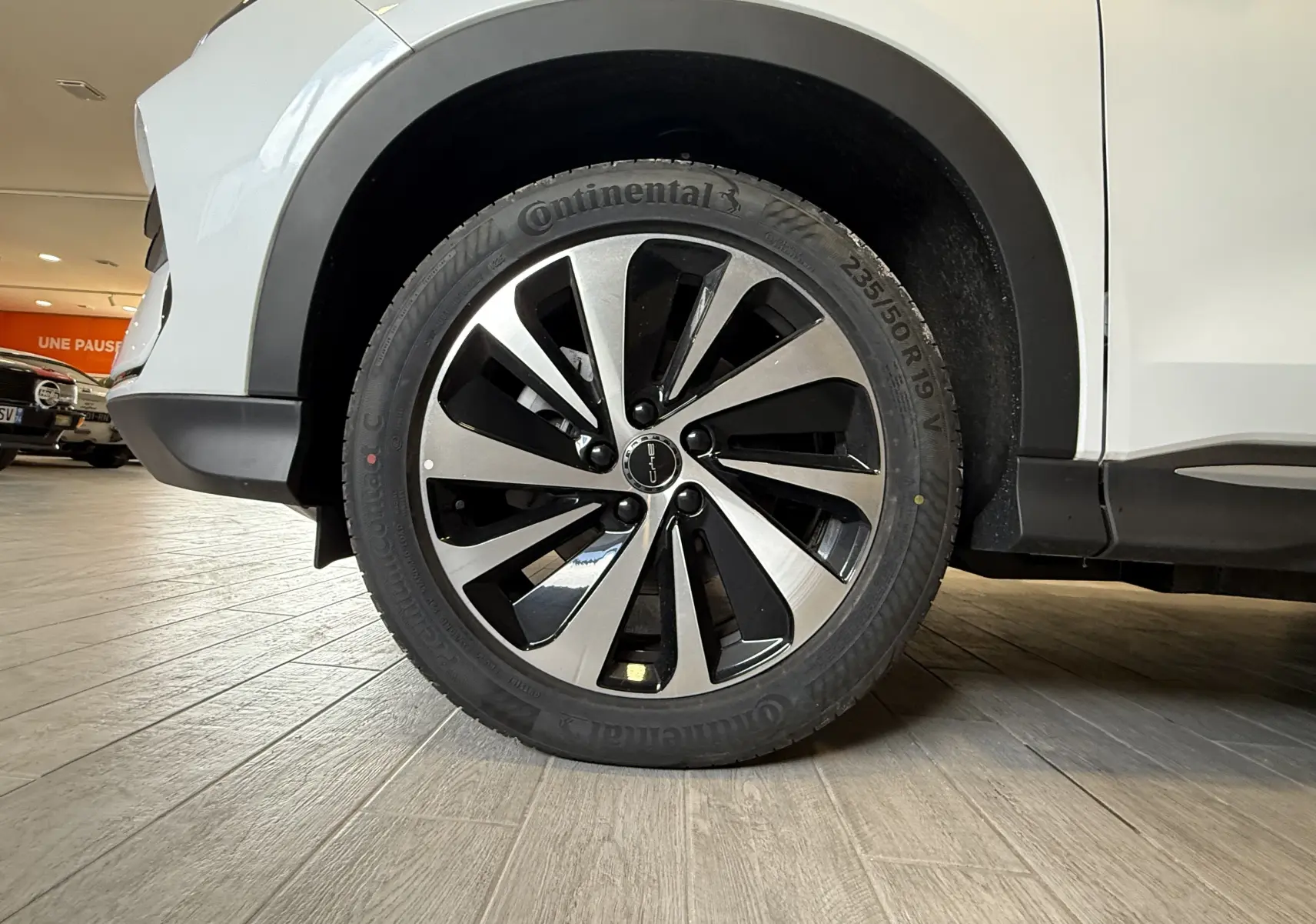 Gros plan sur la roue avant droite du BYD SEAL U blanc métal, mettant en valeur la jante bicolore et le pneu Continental.