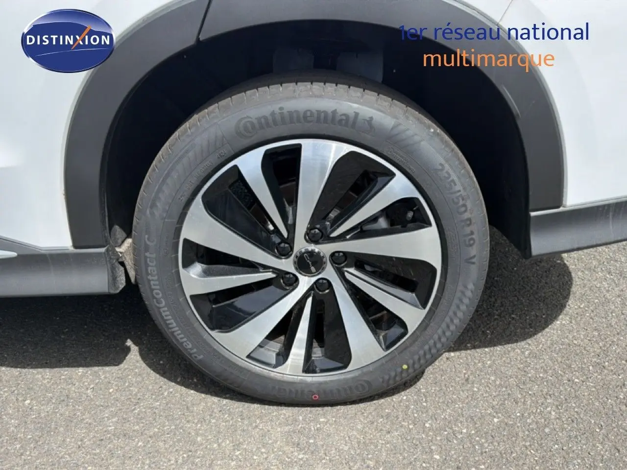 Gros plan sur la roue avant droite d’un BYD SEAL U blanc métal avec jante alliage bicolore et pneu Continental.