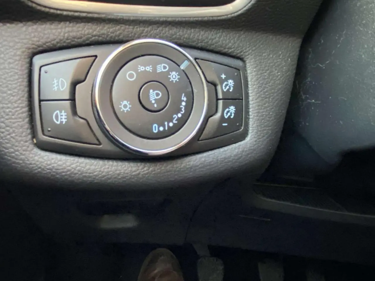 Gros plan sur la commande des feux et réglage de luminosité du tableau de bord d'une Ford B-MAX blanche de 2014.