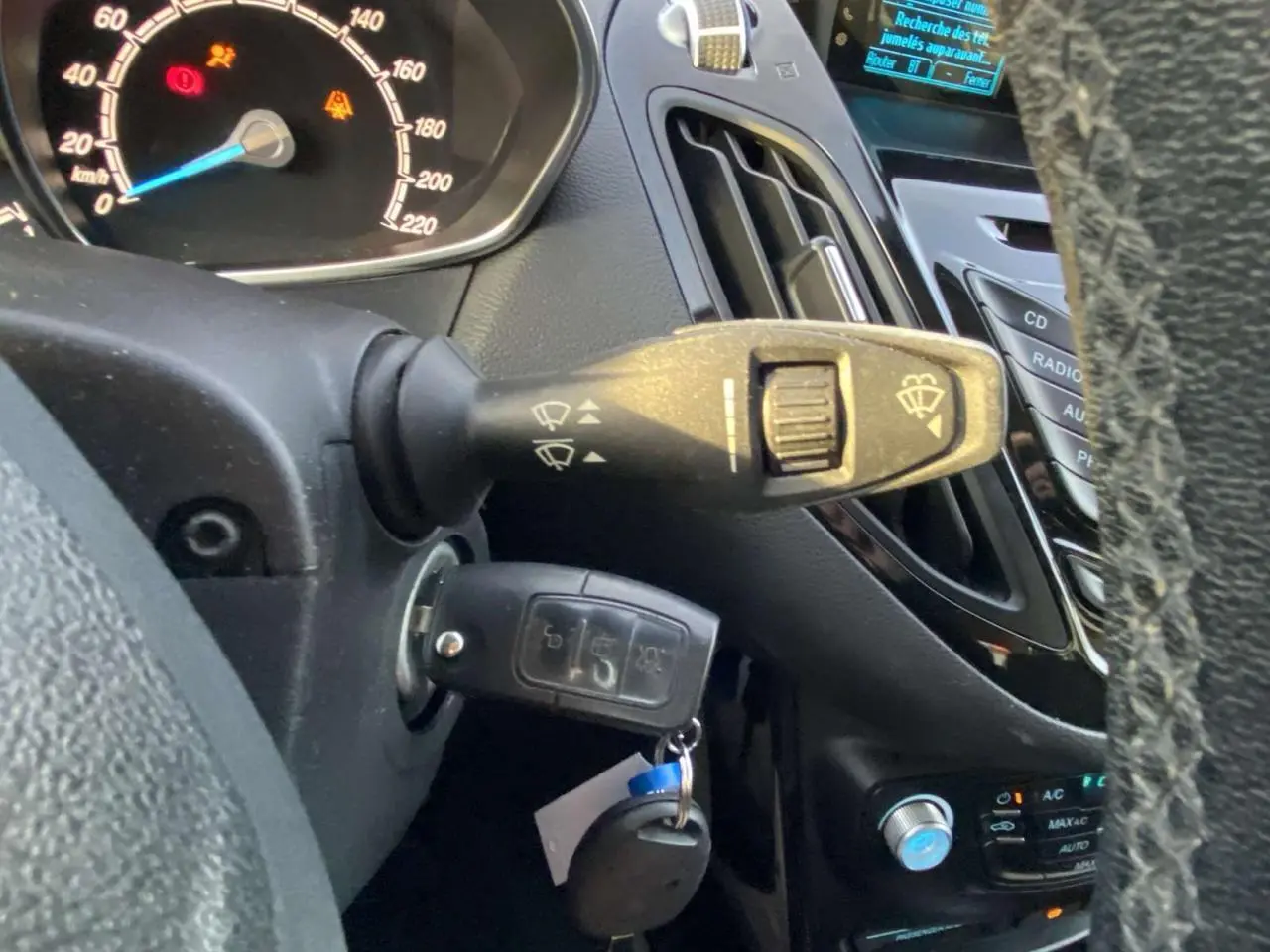 Vue rapprochée du tableau de bord et de la clé dans le contact d'une Ford B-MAX blanche de 2014.