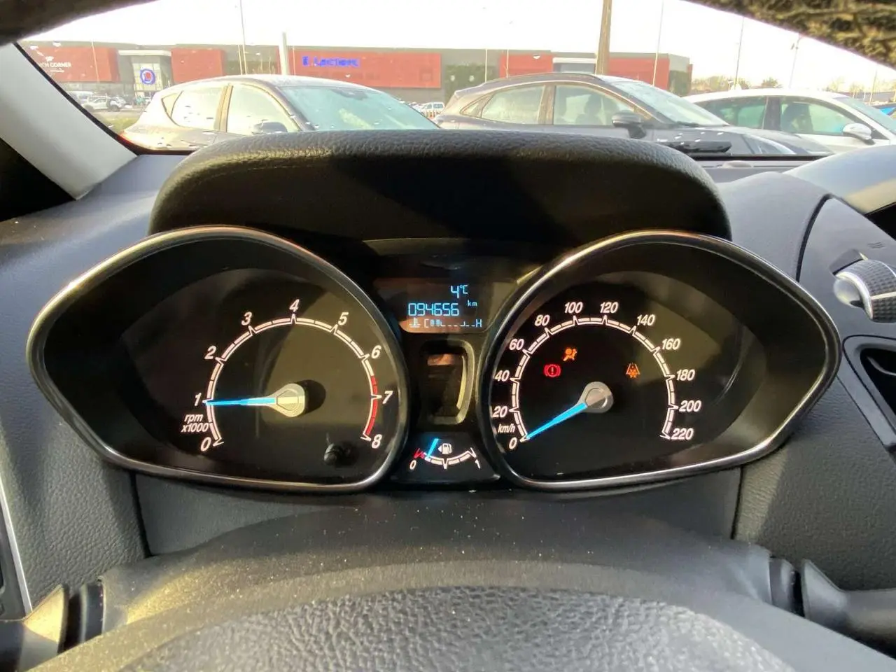 Vue intérieure du tableau de bord de la Ford B-MAX blanche de 2014, affichant le compteur et le compte-tours.