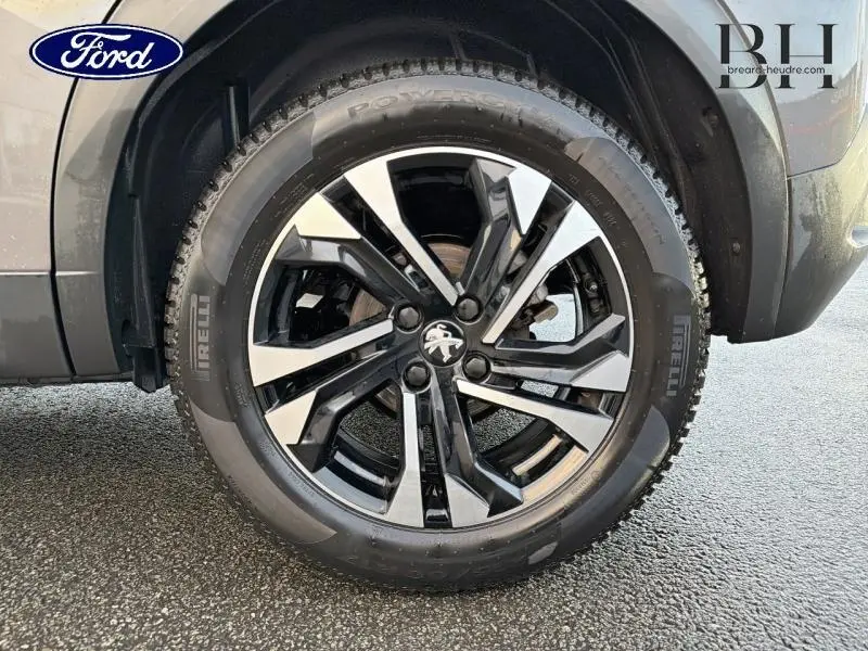 Gros plan sur la jante alu noire et argentée du côté arrière droit d'un Peugeot 2008 gris Artense 2021.