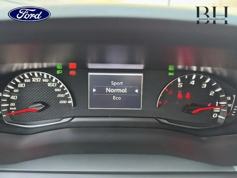 Vue rapprochée du tableau de bord numérique d'une Peugeot 2008 affichant les modes de conduite Sport, Normal et Eco.