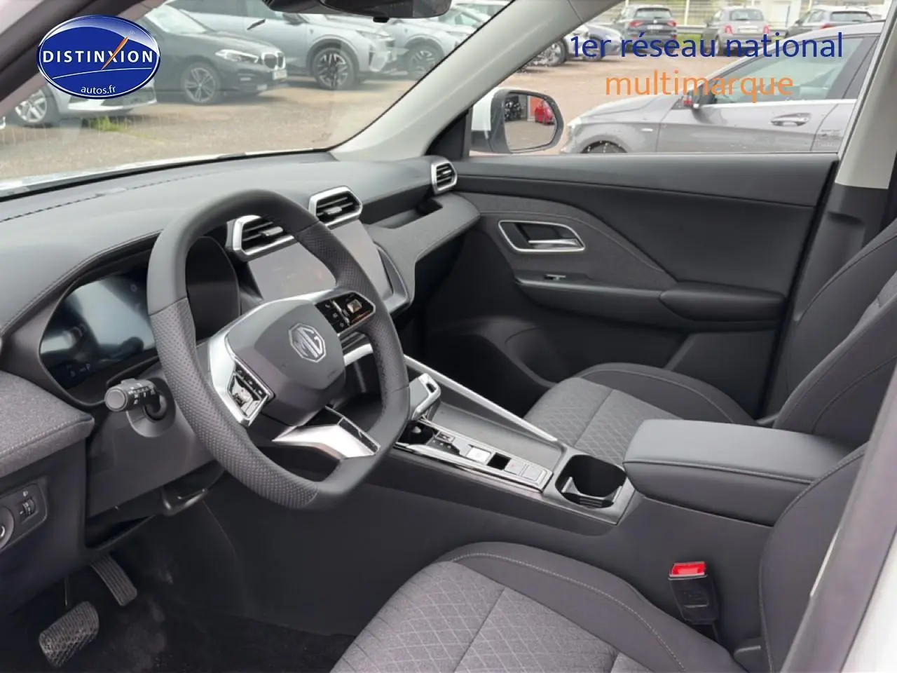 Vue intérieure côté conducteur du MG ZS Hybrid 2026 avec volant multifonction, écran tactile et sièges gris.