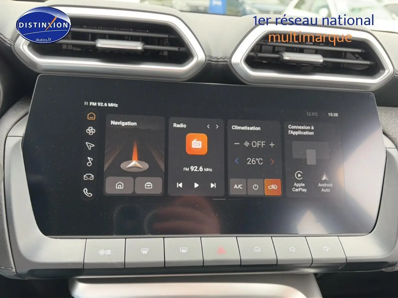 Gros plan sur l'écran tactile central du tableau de bord du MG ZS Hybrid blanc, affichant navigation et climatisation.