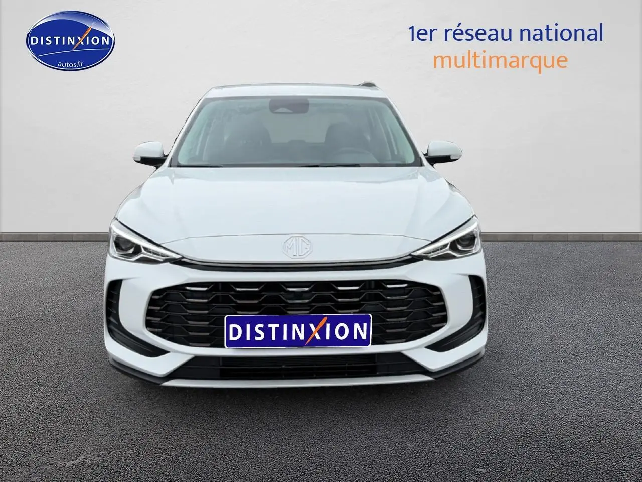 Vue frontale d’un MG ZS Hybrid blanc 2026 avec calandre noire et phares LED fins, sur fond neutre.