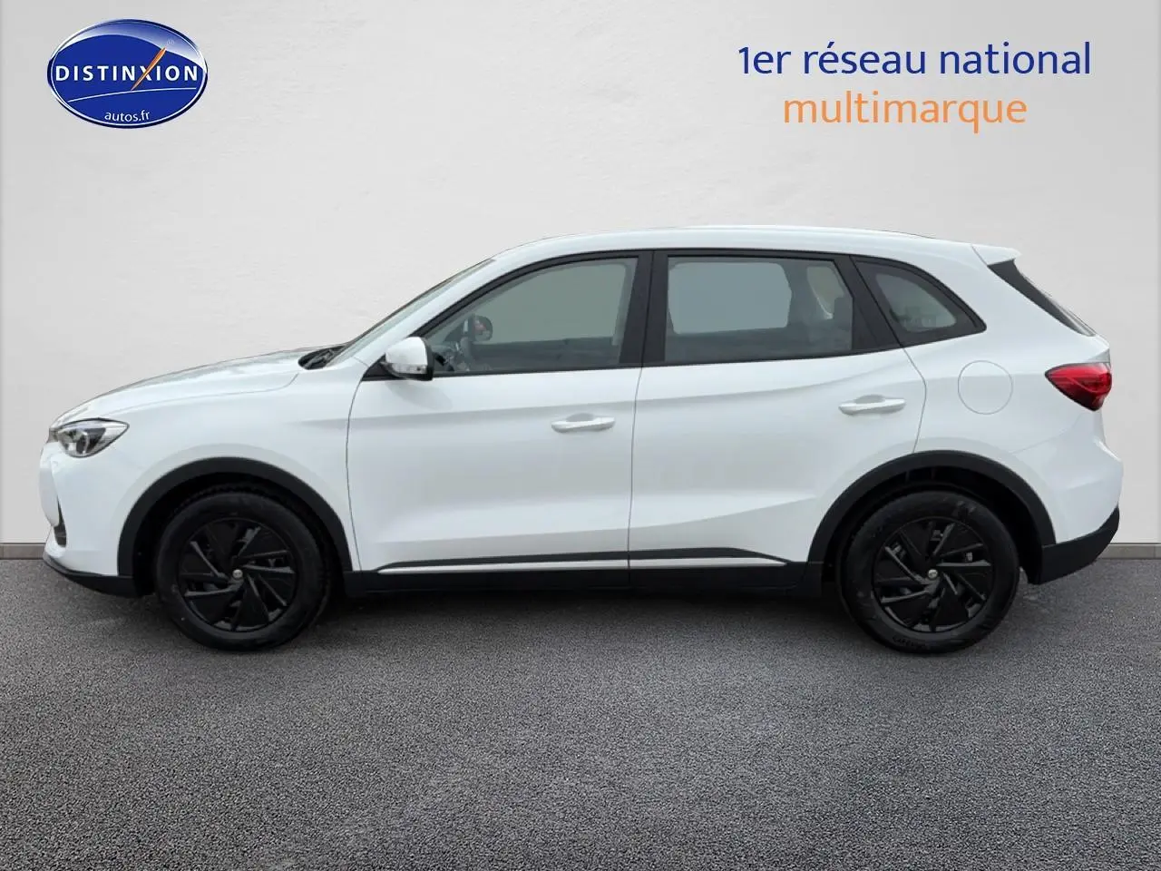 Vue de profil côté gauche d'un MG ZS Hybrid blanc avec jantes noires et lignes épurées sur fond neutre.
