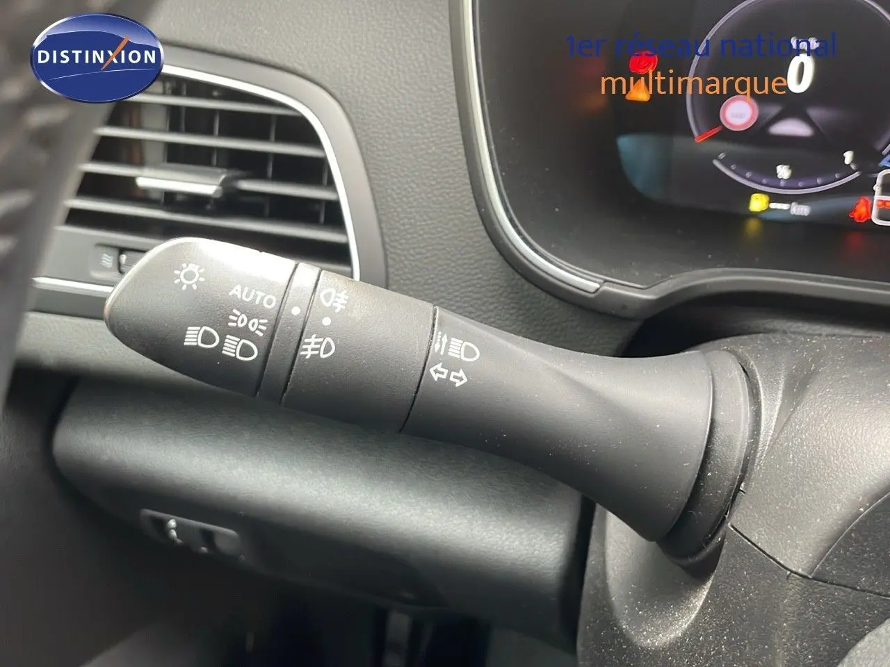 Le commodo d'éclairage noir du tableau de bord d'une Renault Mégane Break gris Highland Metal, vue intérieure.