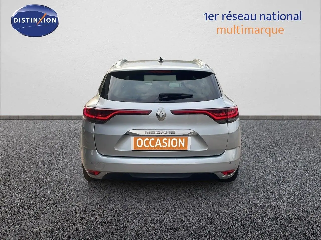 Vue arrière d'une Renault Mégane Break gris Highland Metal de 2024 avec feux LED étirés et plaque occasion.