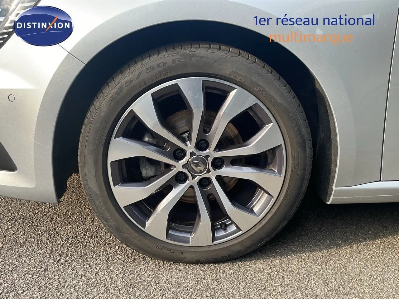 Gros plan sur la roue avant gauche de la Renault Mégane Break gris Highland Metal avec jante alliage bi-ton.