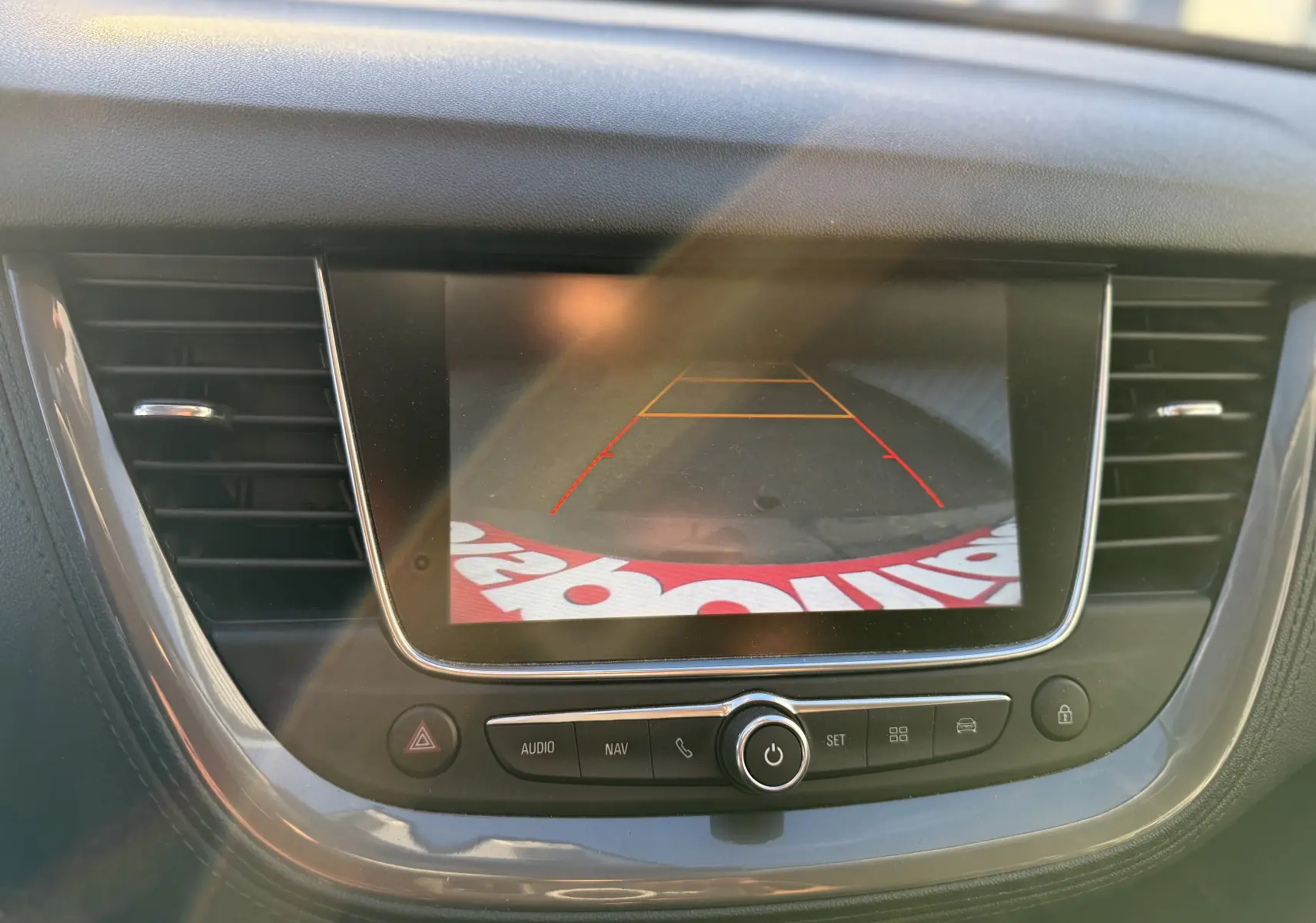 Écran central de l’Opel Grandland X 2019 montrant l’image de la caméra de recul avec les lignes de guidage rouges et jaunes.