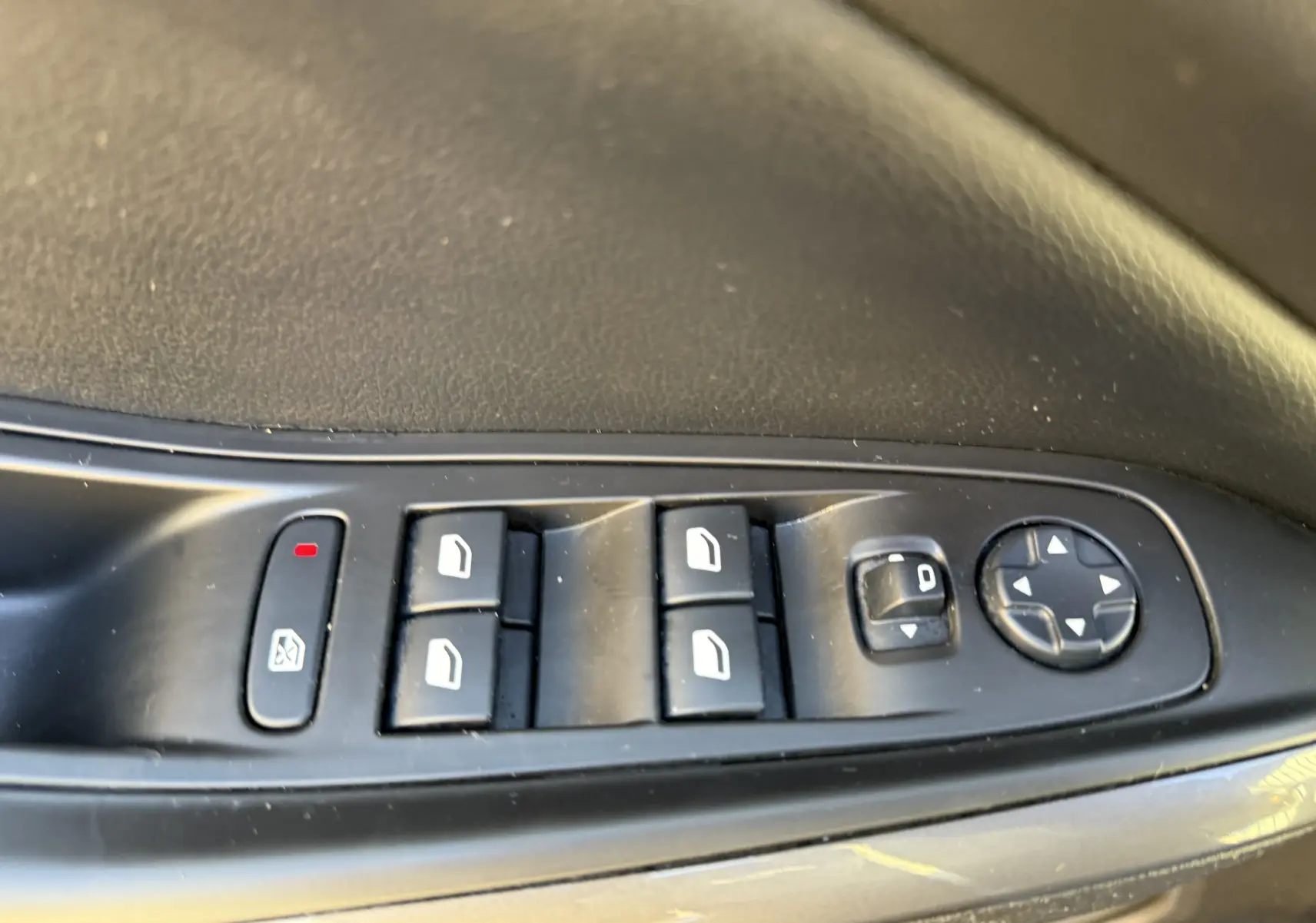 Commandes électriques des vitres et rétroviseurs sur la porte côté conducteur d'un Opel Grandland X gris quartz de 2019.