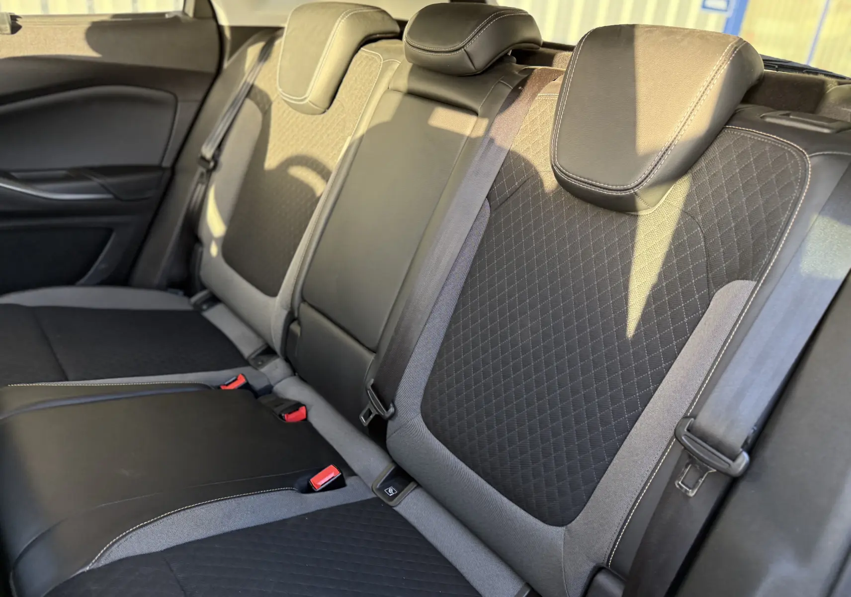 Vue latérale droite des sièges arrière en tissu noir et cuir gris du Opel Grandland X 2019, avec appuie-têtes et ceintures visibles.