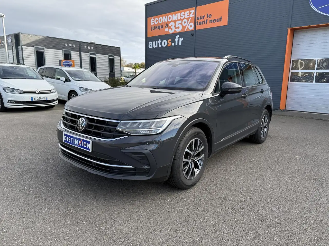 Volkswagen Tiguan gris Urano en 3/4 avant droit, avec jantes alliage Dark Graphite et calandre chromée.