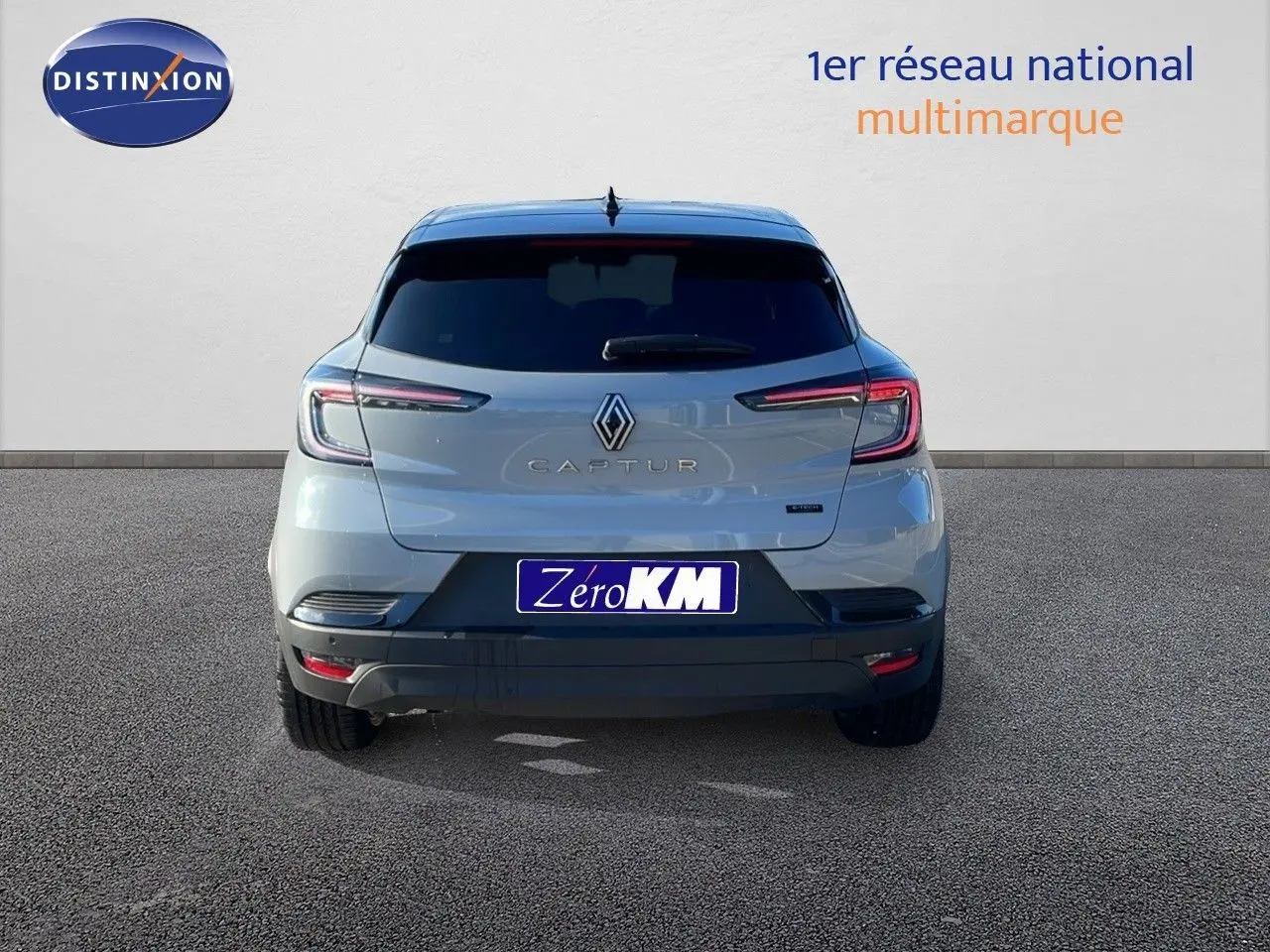 Vue arrière d'un Renault Captur E-Tech hybride gris Rafale avec toit noir, feux LED et plaque Zero KM.
