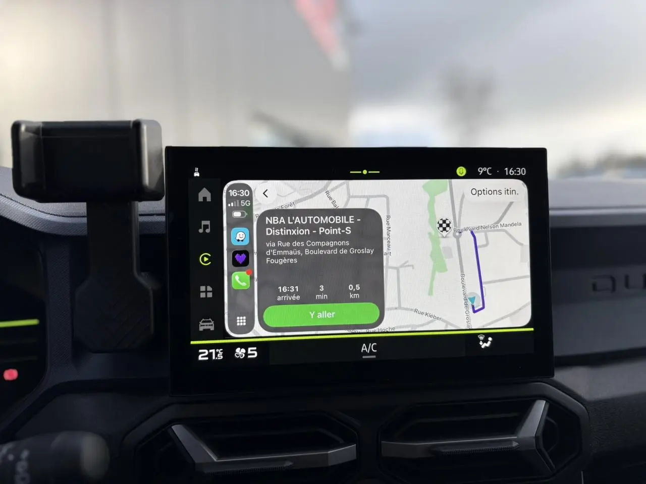 Écran tactile central du Dacia Duster 2024 affichant la navigation, avec tableau de bord et support téléphone visibles.