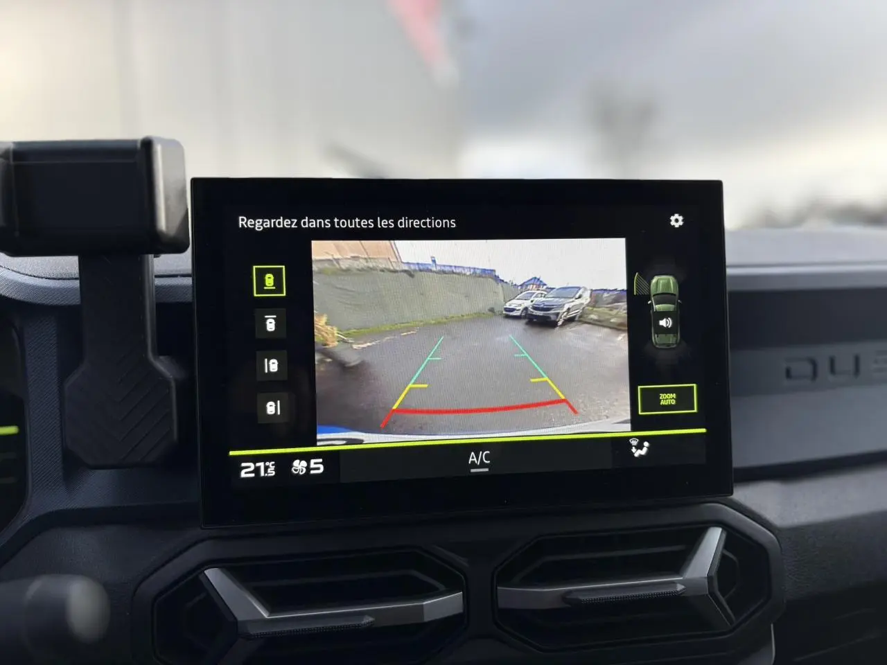 Écran central du Dacia Duster 2024 affichant la caméra de recul avec vue arrière et guidage coloré.