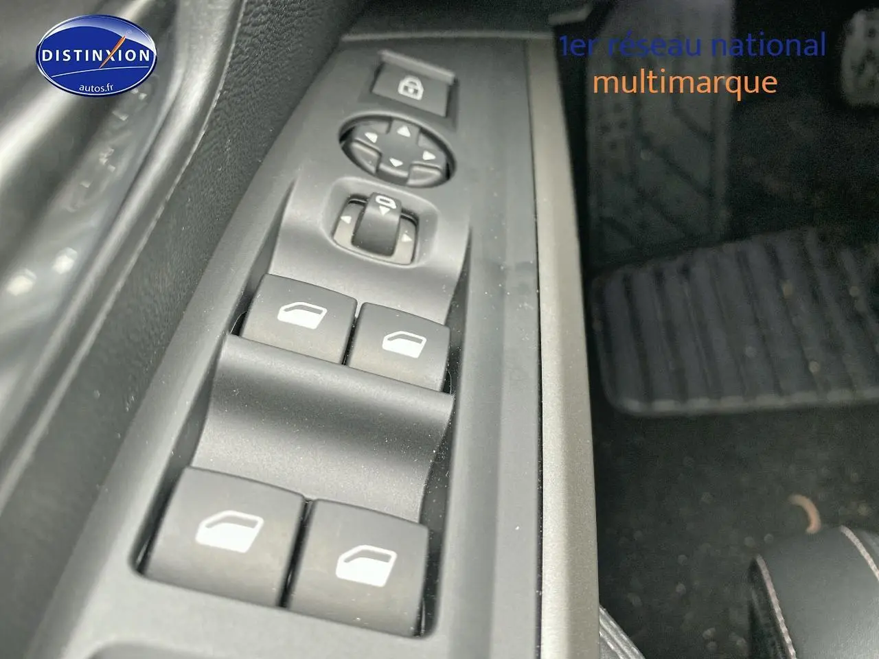 Gros plan sur les commandes de lève-vitres et rétroviseurs côté conducteur du Peugeot 3008 bleu, intérieur noir.