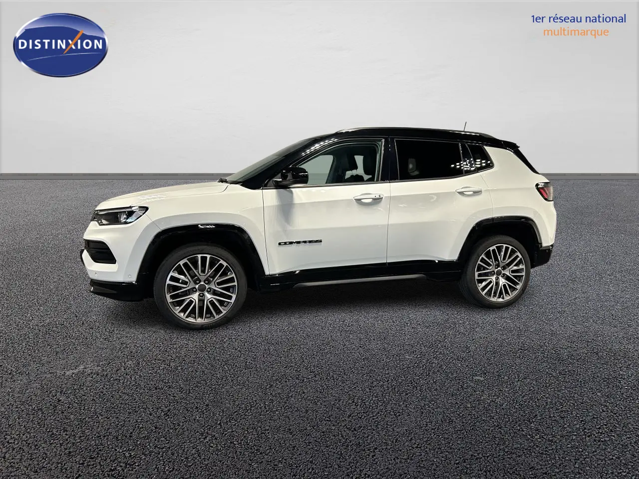 Vue de profil côté gauche d'un Jeep Compass blanc avec toit noir et jantes alliage 19 pouces sur fond neutre.