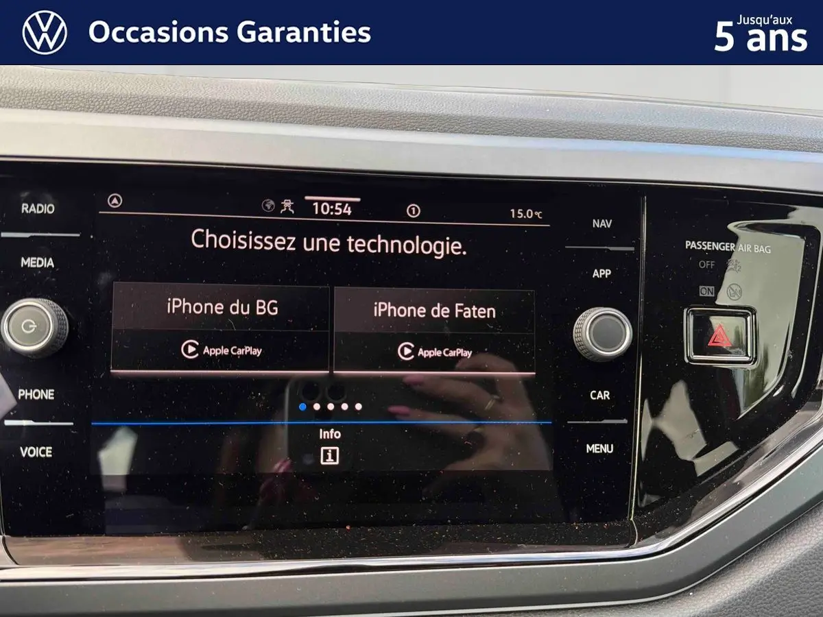 Écran tactile central de la Volkswagen Polo 2025 affichant la connexion Apple CarPlay, avec commandes autour et finition noire brillante.