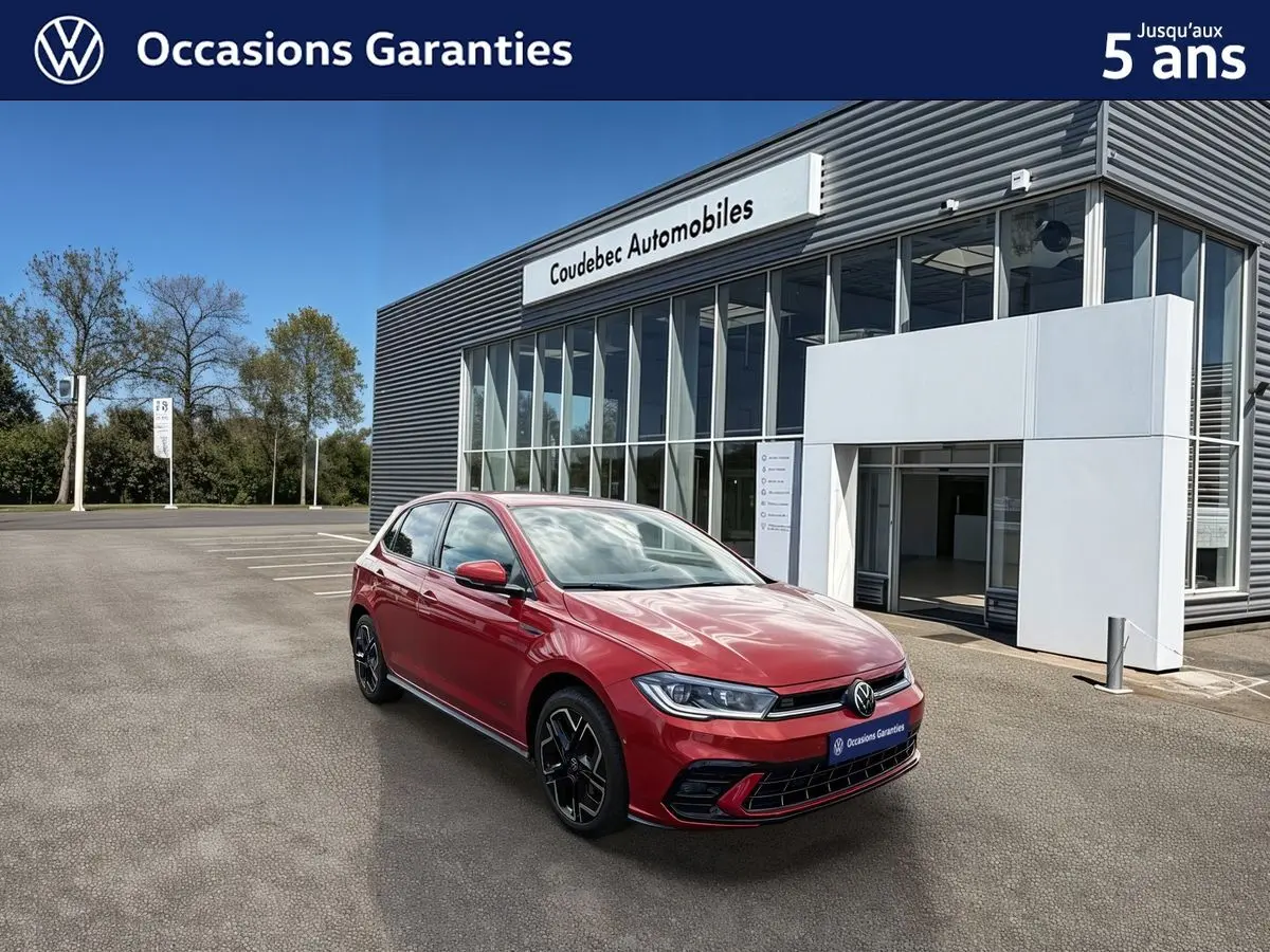 Volkswagen Polo rouge métallisée vue 3/4 avant droit, avec jantes alliage noir et calandre sportive, devant un showroom.