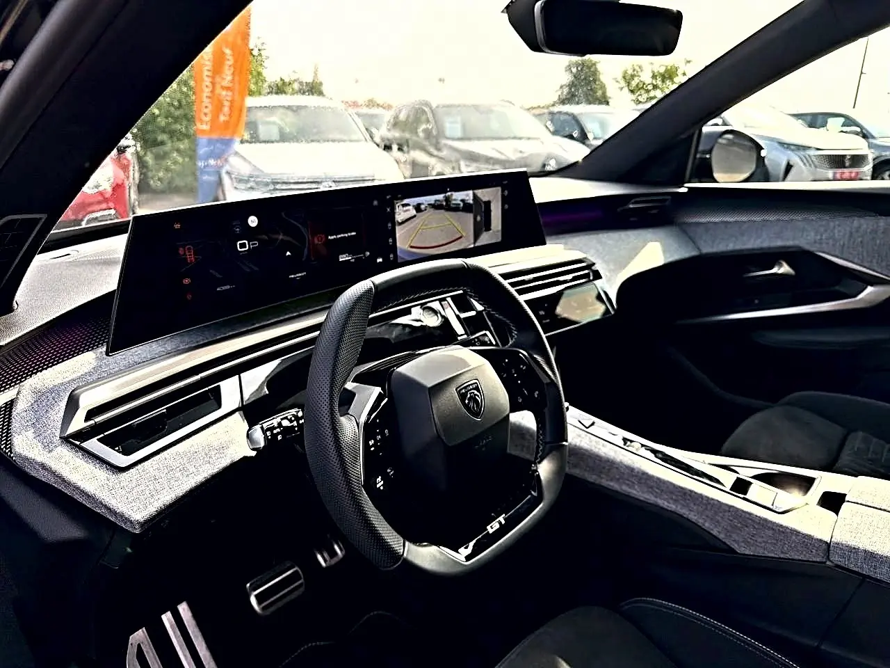 Intérieur du Peugeot 5008 Hybrid 145 GT 2025, vue côté conducteur sur le tableau de bord et volant cuir noir.