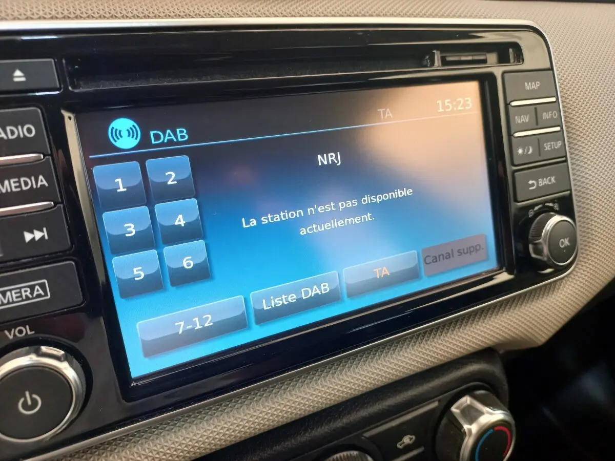 Gros plan sur l'écran tactile multimédia affichant un message d'erreur de station radio dans une Nissan Micra blanche.